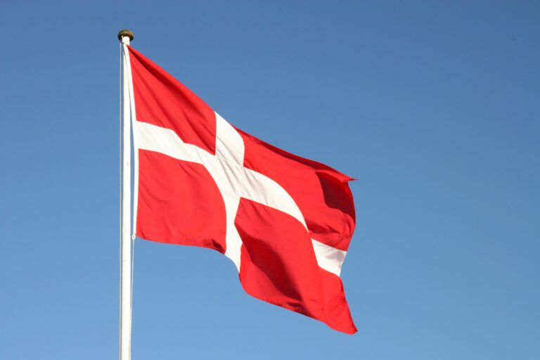 Dannebrog - det danske flag vajer på flagstangen mod en blå himmel